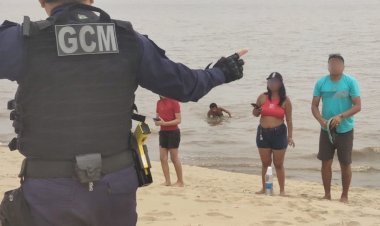 Descumprindo interdição, grupo de banhistas é orientado a sair da praia da Ponta Negra na extrema vazante do rio
